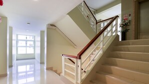 A staircase with a wooden handrail and beige steps, leading to an upper floor. - Salin Home Hotel Ramkhamhaeng (Bangkok)