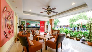 A hotel lobby with a seating area, a ceiling fan, and potted plants. - Salin Home Hotel Ramkhamhaeng (Bangkok)