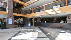 A spacious lobby with a stone pillar, a reception desk, and a staircase leading to upper floors. - Coming soon! Coming soon! Coming soon! Coming soon! Coming soon! (Park City)