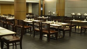 Un restaurante con varias mesas y sillas, dispuesto en un espacio amplio.