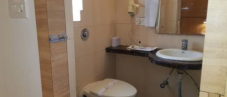 A compact bathroom with a toilet, sink, and mirror.