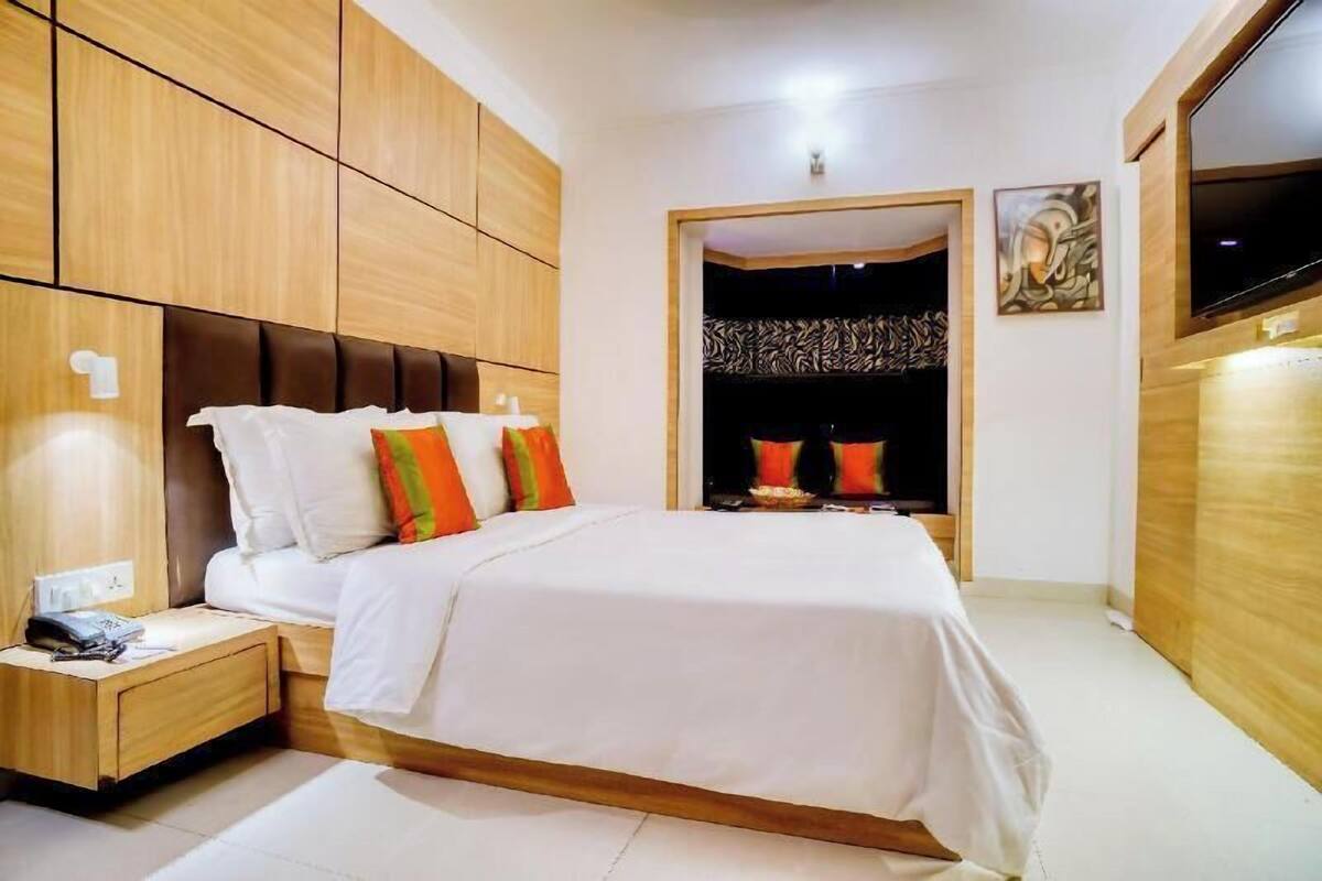 Un dormitorio con cama, armario de madera y televisor.