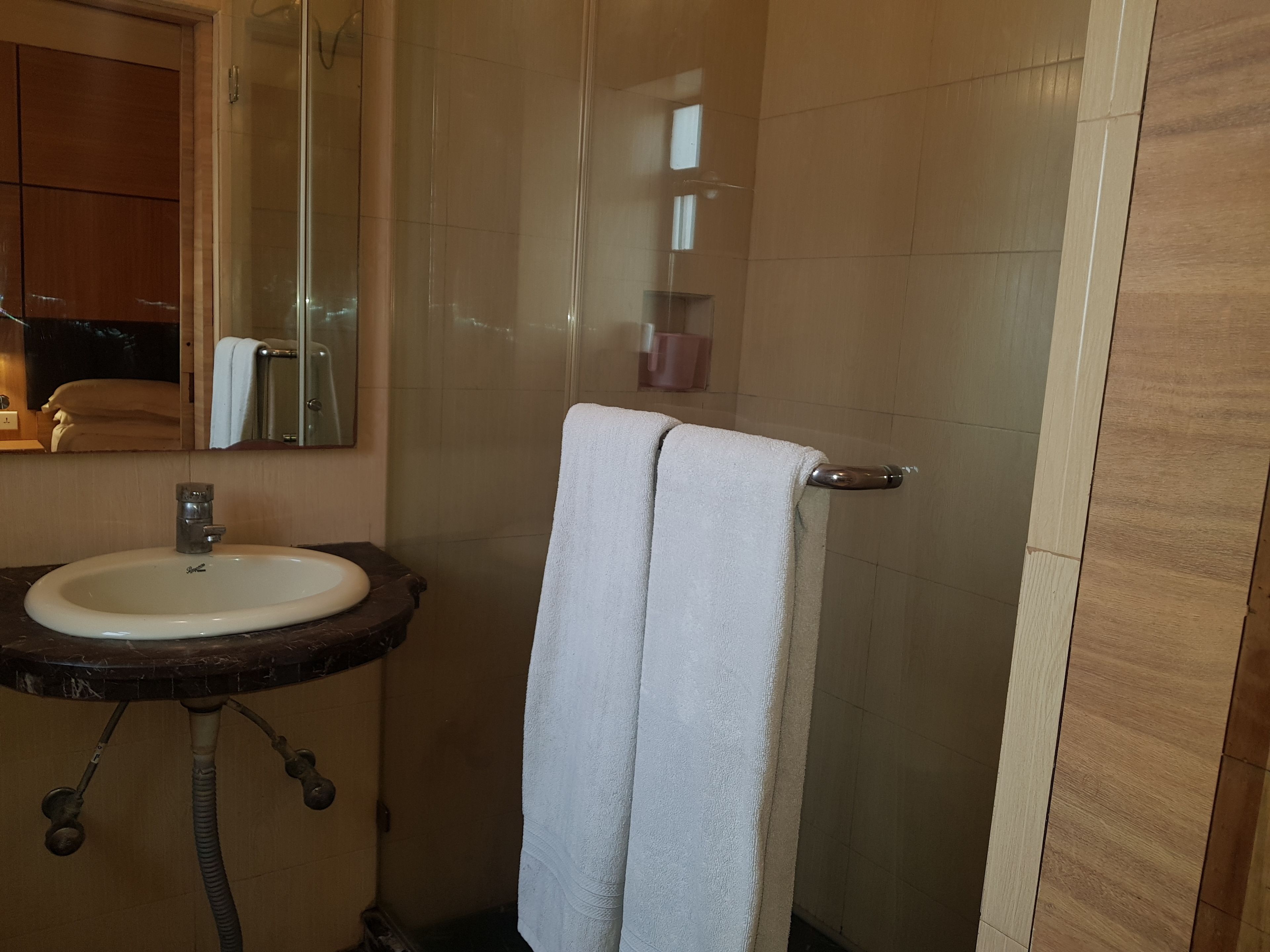 A bathroom with a sink, mirror, and towel rack.