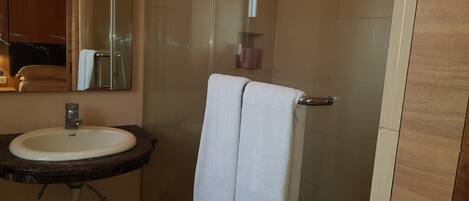 A bathroom with a sink, mirror, and towel rack.