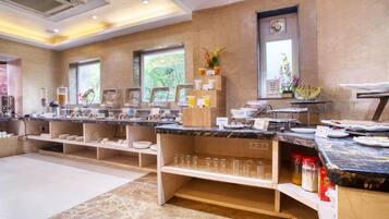 A modern breakfast bar with marble countertops, glassware, and a variety of breakfast items.