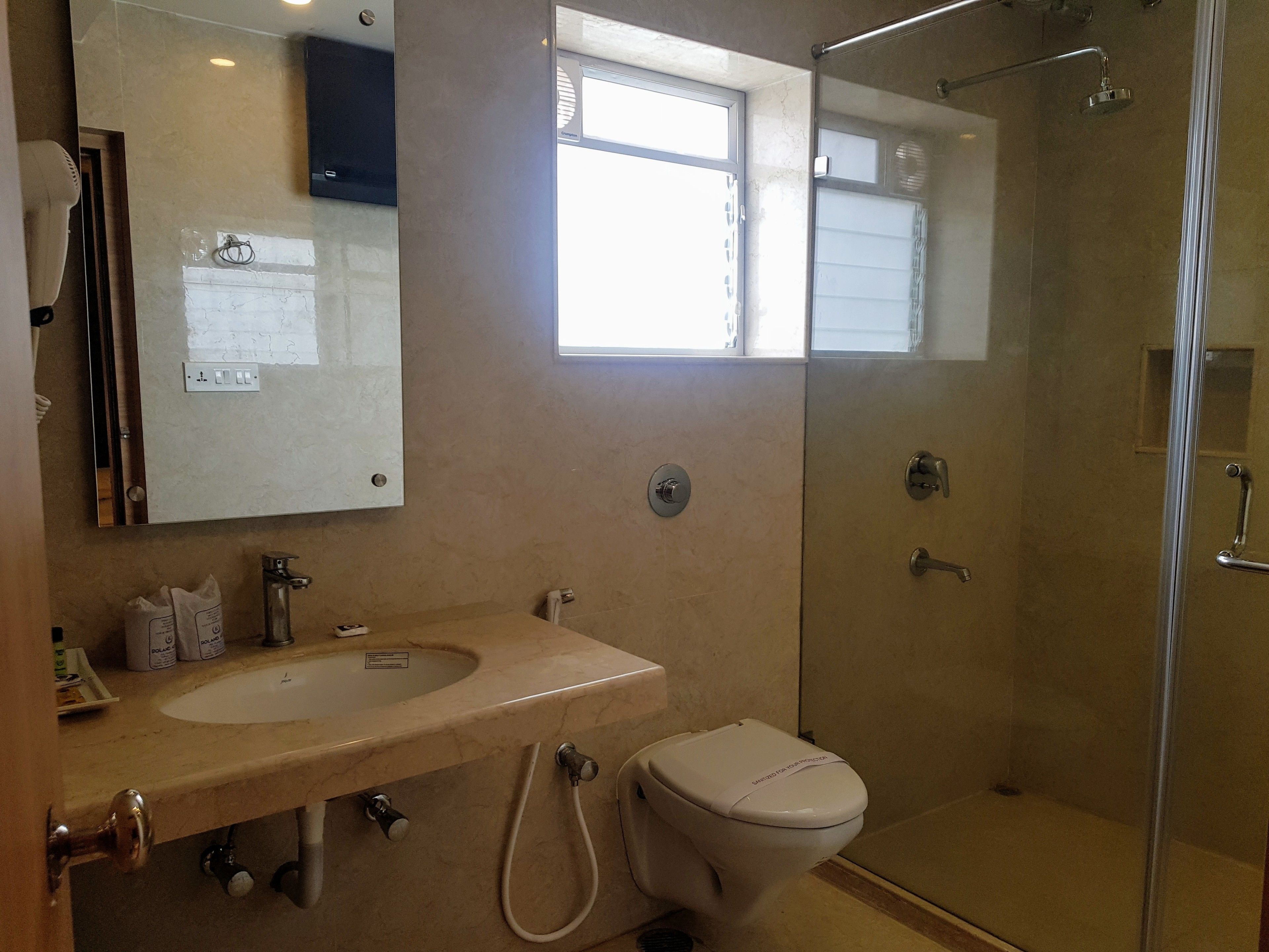 Un baño con lavamanos, inodoro y ducha con mampara de vidrio.