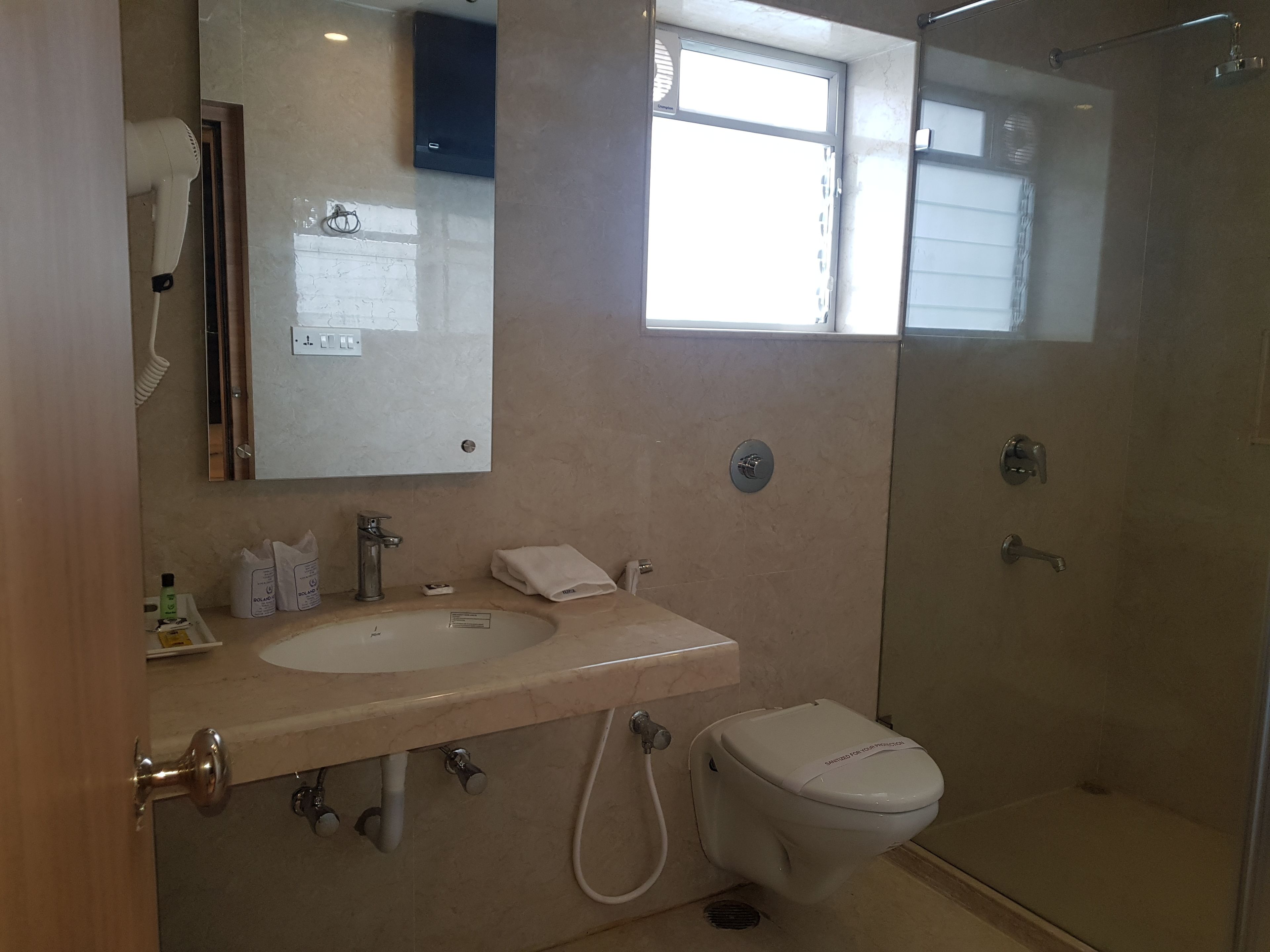 A modern bathroom with a sink, mirror, and toilet.