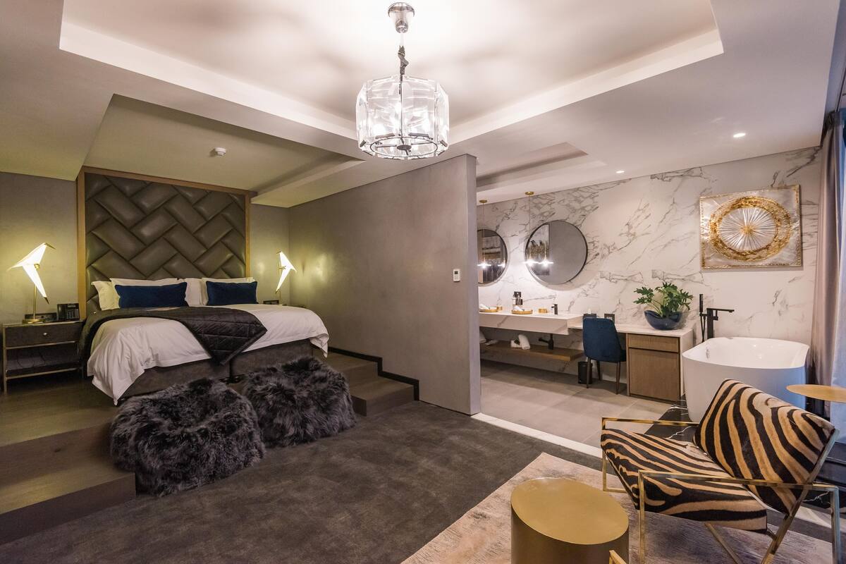 Ein modernes Schlafzimmer mit Bett, Schminktisch und Bad.
