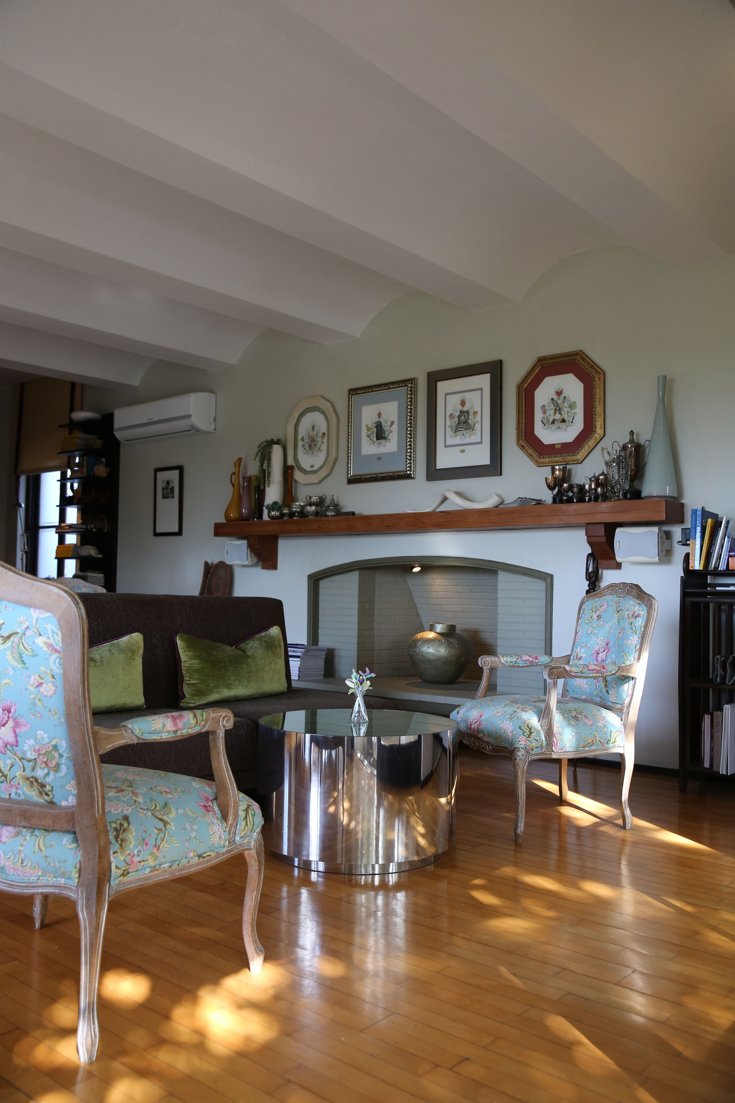 A living room with a sofa, two chairs, a coffee table, and a fireplace.