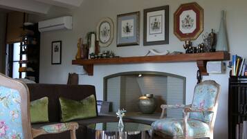 A living room with a sofa, two chairs, a coffee table, and a fireplace.