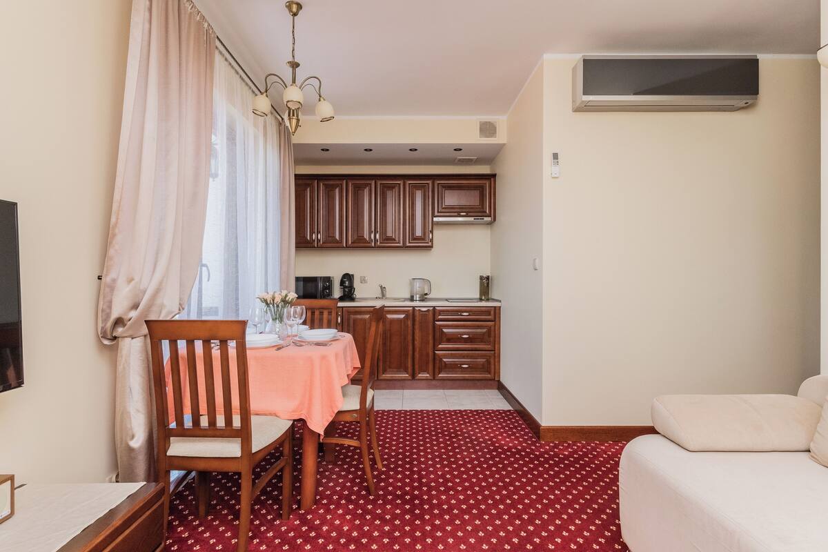 Un espacio habitable compacto con comedor, kitchenette y sofá.