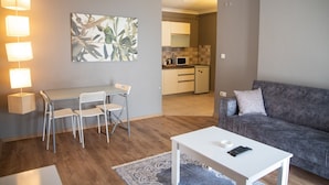 A compact living space with a dining area, a sofa, and a kitchen in the background. - The Hera Suit Hotels (Istanbul)