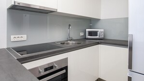 A modern kitchen with a stainless steel sink, a microwave, and a built-in oven. - Dva Galeba - Comfort One Bedroom Apartment with Sea View (205) (Bol)