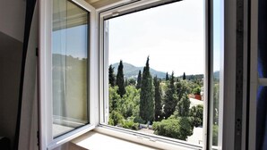 Una ventana con vistas a un paisaje montañoso y árboles.