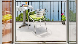 A balcony with a table and chairs, a view of the sea, and a railing. - Villa Kosa - Two Bedroom Apartment with Balcony and Sea View (Roko) (Brela)
