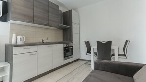 Una cocina moderna con gabinetes grises, un horno empotrado y una encimera blanca.