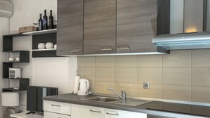 Una cocina moderna con armarios de madera oscura, un lavamanos de acero inoxidable y un salpicadero de azulejos.