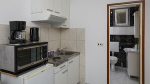 A compact kitchen with a microwave, coffee maker, and sink. - Apartment Brane - Studio Apartment (Mokosica)