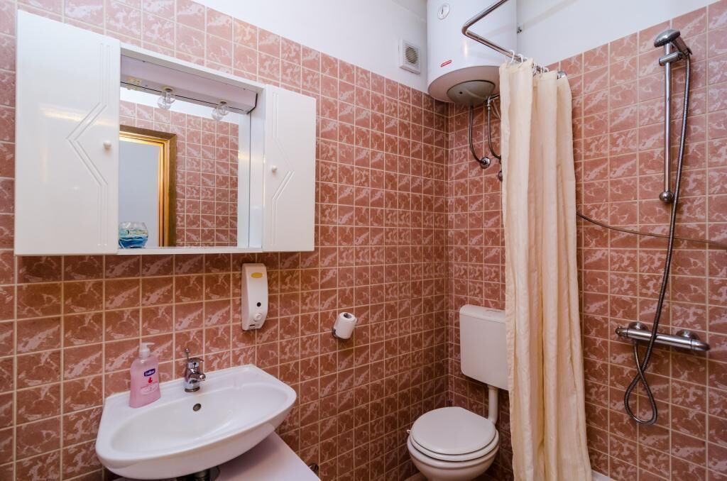 Ein Badezimmer mit Waschbecken, Toilette, Dusche und Spiegel.