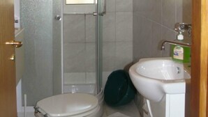 Een badkamer met toilet, wastafel en douche.