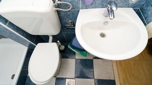 Un baño con inodoro, bidé y lavamanos.