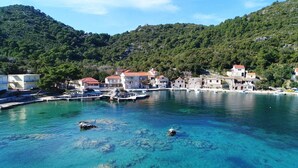 Un village côtier aux bâtiments en pierre, aux eaux turquoise et limpides, et aux rives rocheuses.