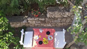 Ein Picknickdekor mit kariertem roten Tischläufer, zwei Tellern mit Essen, einer Kanne und einem Korb.