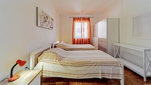 Een slaapkamer met een bed, bureau, stoel en kledingkast.