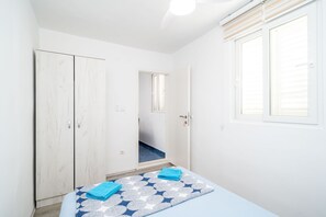 A bedroom with a bed, a wardrobe, a window, and a door leading to a hallway. - Apartment & Rooms Alan-Double Room with Shared Bathroom 2 (Dubrovnik)