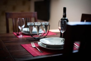 A beautifully set table awaits your meal, complete with fine wine glasses and a stylish plate.