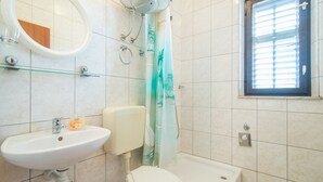 A bathroom with a sink, toilet, and shower. - Apartments Neva- Two Bedroom Apartment with Balcony (4R) (Selca)