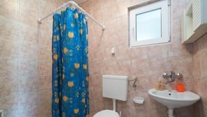 A bathroom with a toilet, sink, and shower curtain.