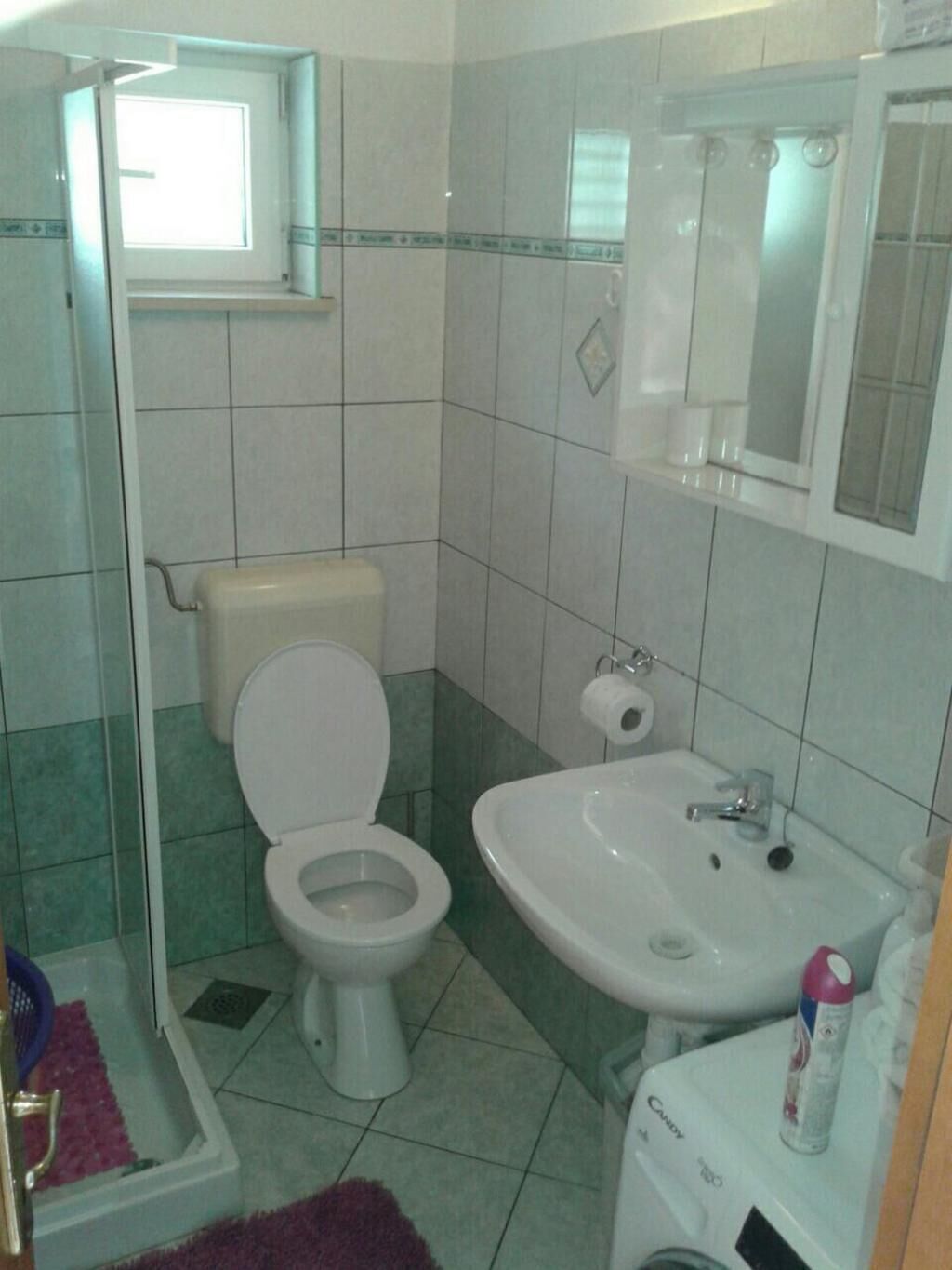 A bathroom with a toilet, sink, and shower.
