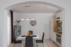 A modern kitchen with white cabinets, a built-in oven, and a microwave.