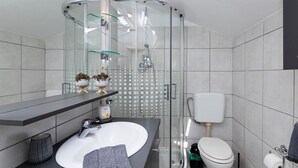 A modern bathroom with a glass-enclosed shower, a white sink, and a toilet. - Apartments Roda - Comfort One Bedroom Apartment with Terrace (Supetar)