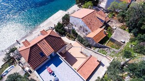 Une propriété située en bord de mer, dotée d’une piscine, de toits en terrasses et offrant une vue sur la plage.