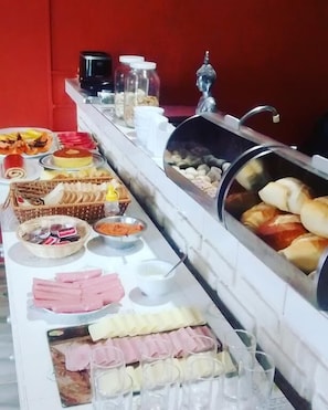 Un bufé con diferentes opciones de comida, como pasteles, carnes y verduras.