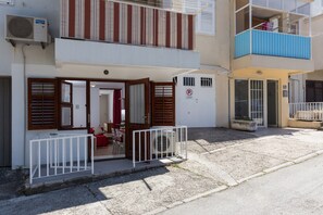 En toetagers bygning med balkon, port og et lille udendørs siddeområde.