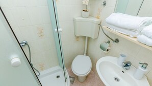 Een badkamer met toilet, wastafel en douche.