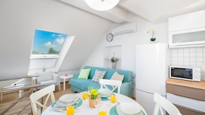 Ein moderner, gut beleuchteter Wohnraum mit Essbereich, Küchenzeile und Blick ins Freie.