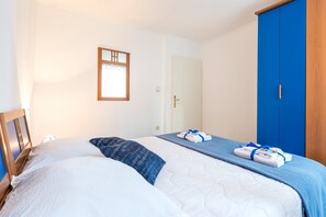 Une chambre d’hôtel avec un grand lit, une armoire et une fenêtre avec des rideaux.