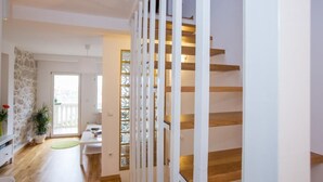 A modern interior with a staircase, a dining area, and a view of the outdoors.