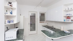 A modern kitchen with white cabinets, a marble countertop, and a built-in oven. - Apartment Rea-Three Bedroom Apartment with Sea View (Dubrovnik)