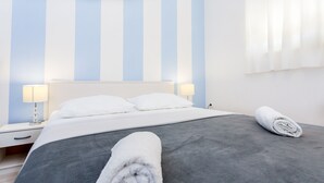 A hotel room with a large bed, two bedside lamps, and a window with curtains. - Magdales - Two Bedroom Apartment with Balcony (Omis)