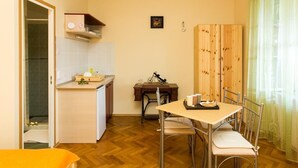 A compact kitchen with a dining area, a small table, and chairs. - Villa Iveta- Triple Room (Ground Floor) - Martina (Dubrovnik)