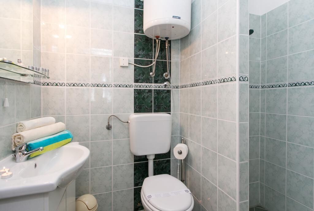 A bathroom with a toilet, sink, and shower.