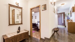 A hallway with a wooden bench, a mirror, and a small stool with a bowl. - Holiday home Villa Spilla - Three Bedroom Home with Terrace (Selca)