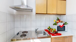Une cuisine moderne équipée d’une cuisinière en acier inoxydable, d’un évier et de meubles de rangement en bois au-dessus.