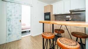 Una cocina moderna con armarios de madera, un horno negro y una barra con taburetes.