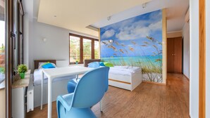Un dormitorio con una cama, un escritorio y una silla. Hay una ventana y una puerta.